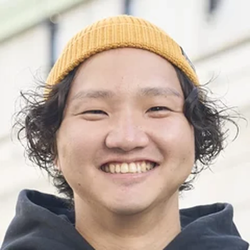 ニット帽をかぶって笑う川合 匠