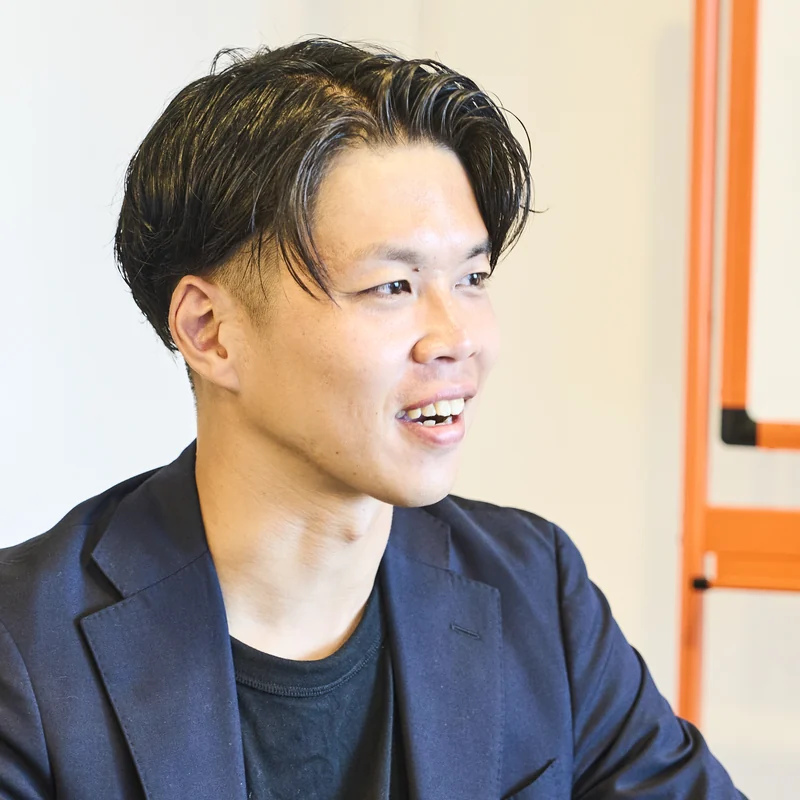 打ち合わせ中に笑顔で話す室谷 拓実