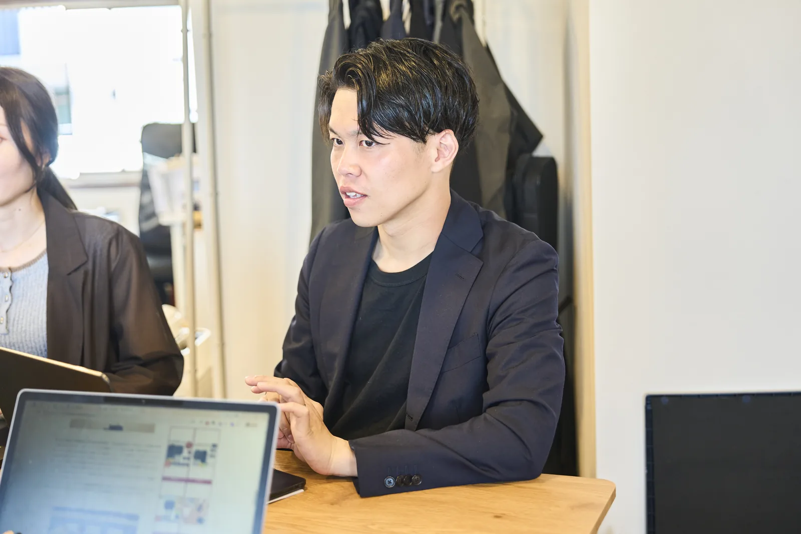 打ち合わせで、資料を見ながら話すスタッフ