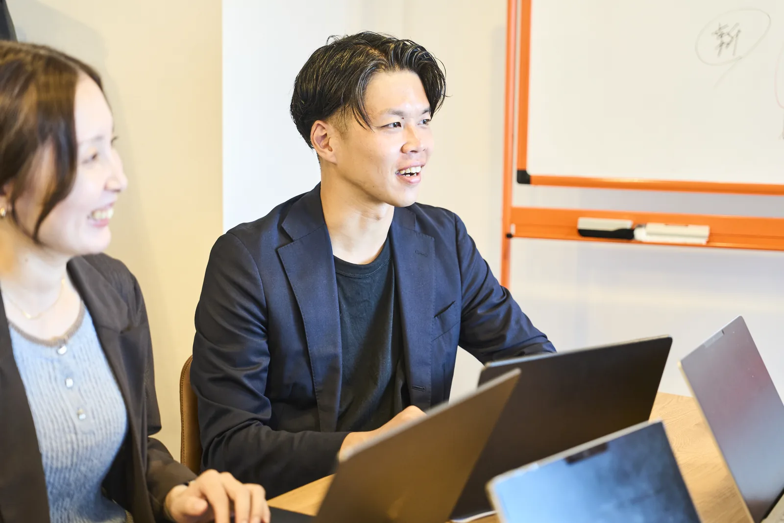 打ち合わせで、笑顔で話を聞くスタッフ