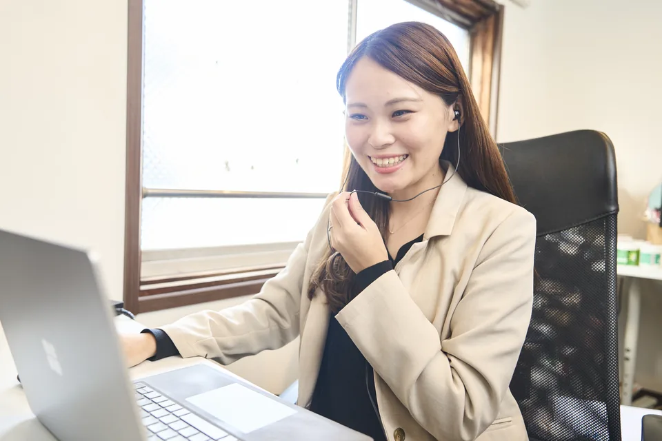 イヤホンをつけて、ノートPCの向こうの参加者に話しかけるスタッフ