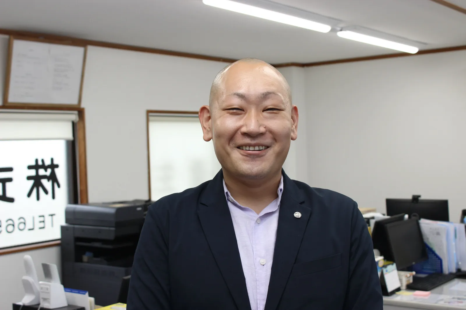 オフィスで笑顔を見せる竹田社長