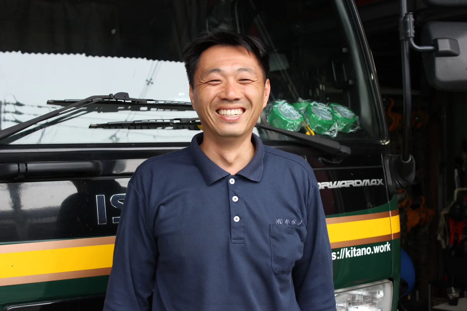 トラックの前で笑う北野社長