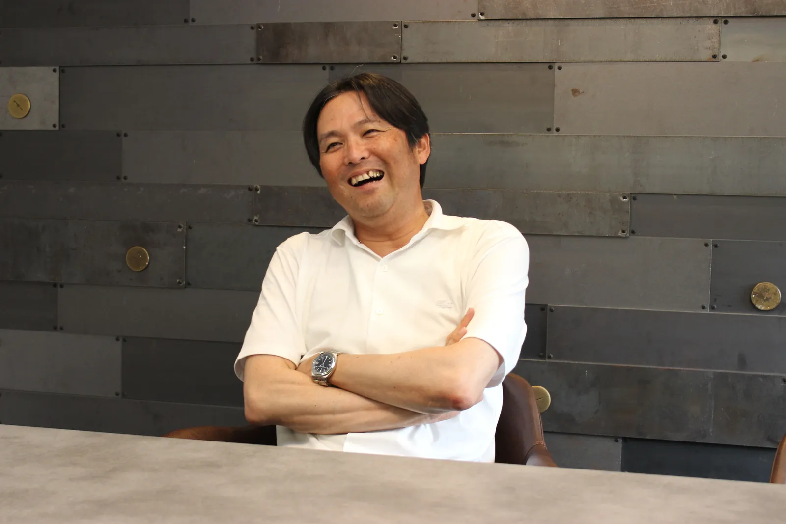腕を組んで笑う中三川社長