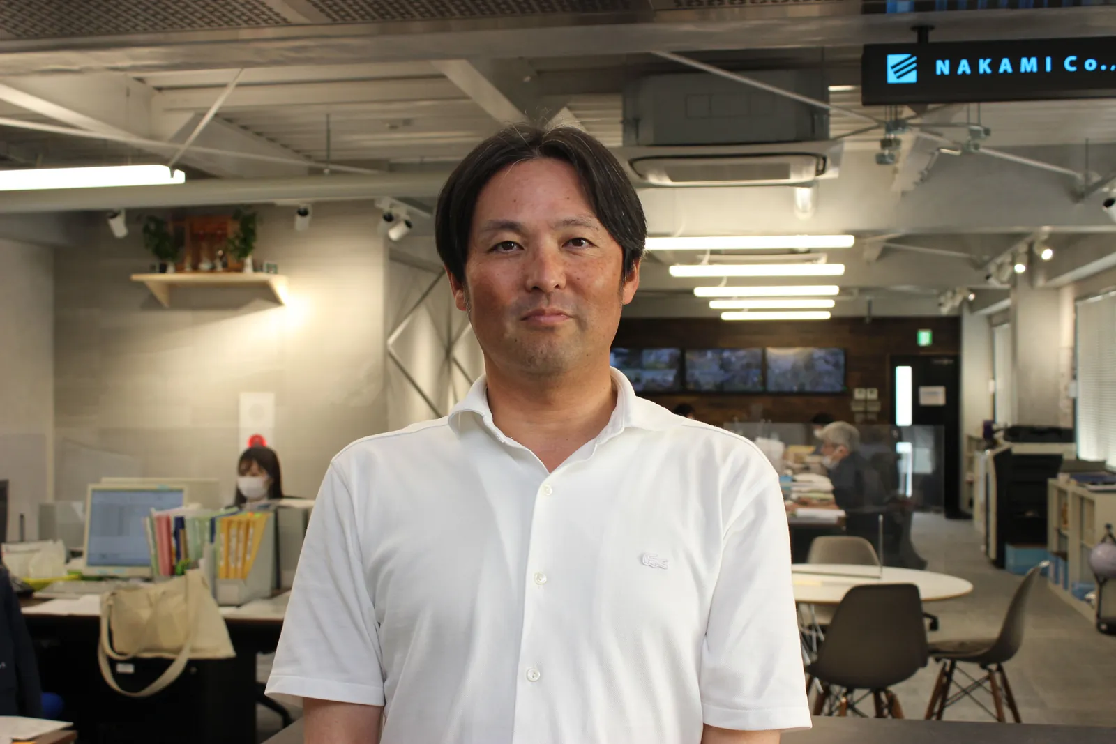 オフィスの中で立つ中三川社長