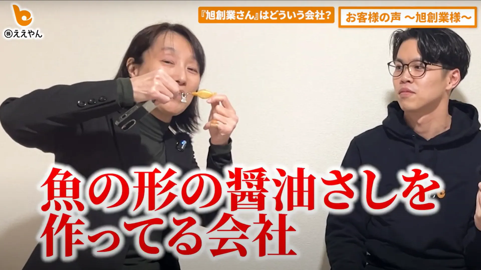 ランチャームを手に、会社を紹介するインタビューの様子（動画より）